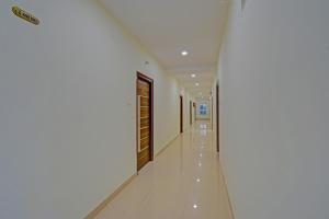 a corridor of a building with white walls and a door at FabHotel GG Stays in Lingampalli