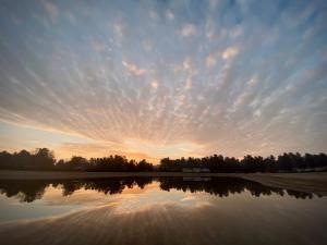 a sunset over a field with a reflection in the water at Arden Parks Tulderheyde in Poppel +7 photos