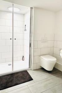 a white bathroom with a shower and a toilet at Das Stader Zuhause in Stade +9 photos