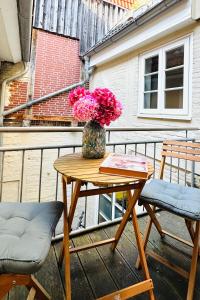 a table with a vase of flowers on a balcony at Das Stader Zuhause in Stade