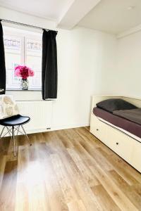 a bedroom with a bed and a chair and a window at Das Stader Zuhause in Stade