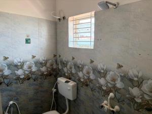 a bathroom with white flowers on the wall at Tova in Mettuppālaiyam