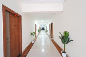 an empty corridor with potted plants in a building at FabHotel Prime Rosens in Māripat +26 photos