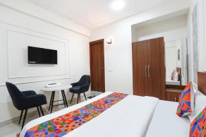 a bedroom with a bed and a table and chairs at FabHotel Prime Rosens in Māripat