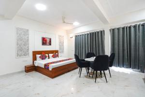a bedroom with a bed and a table and chairs at FabHotel Prime Rosens in Māripat