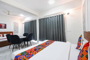 a bedroom with a bed and a table and chairs at FabHotel Prime Rosens in Māripat