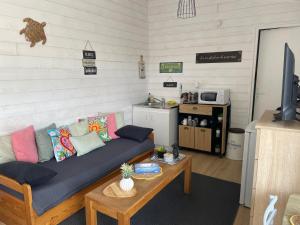 a living room with a couch and a table at O Douceurs Sucrées Cabourg in Cabourg