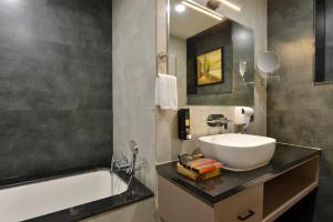 a bathroom with a sink and a bath tub at Ginger Kota, Vishwakarma Nagar in Kota +11 photos