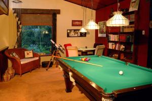 a living room with a pool table and chairs at Casa da Colina Chalés in Visconde De Maua