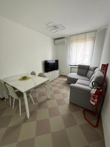 a living room with a table and a couch at Appartamento Centro Direzionale Cerea in Cerea +16 photos