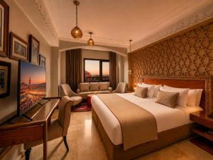 a hotel room with a large bed and a desk at Hivernage Marrakech in Marrakesh