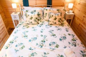 a bed with a floral bedspread and pillows at Rowan in Whithorn