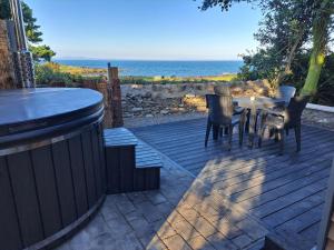 a patio with a table and chairs and the ocean at Rowan in Whithorn