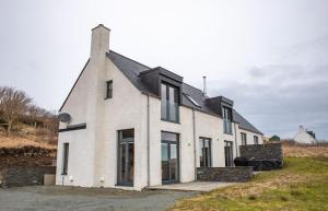 a white house with a black roof at Cnoc Na Lobhta in Husabost