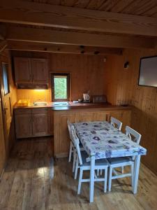 a kitchen with a table and chairs in a cabin at DELFIN - Lawendowy Zakątek in Sianozety