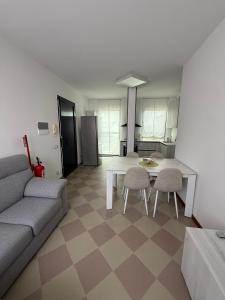 a living room with a couch and a table and chairs at Appartamento Centro Direzionale Cerea in Cerea