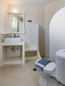 a bathroom with a sink and a toilet and a mirror at Argo-Milos in Adamantas