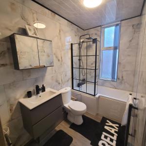 a bathroom with a toilet and a sink and a tub at 6 BR Home Free Parking Sleeps 14 Table Tennis City Centre Pool Table in Central Station +36 photos