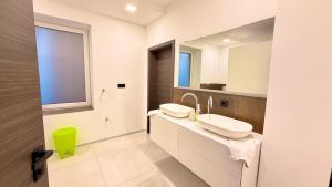 a white bathroom with two sinks and a mirror at Whirlpool Sauna Pool Bad Ems in Bad Ems +31 photos