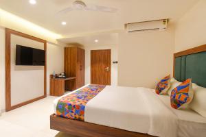 a bedroom with a large bed and a television at FabHotel Shourya Regency in Jāmb