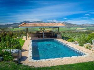 a swimming pool with a gazebo and a swimming poolvisor at Barton Luxury Villas in Hermanus