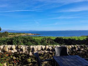 a table and two chairs sitting next to a stone wall at Ivy in Whithorn