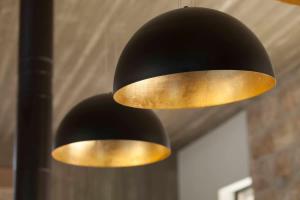 Eine schwarz-goldene Lampe hängt von der Decke in der Unterkunft Villa Pnai in Rosch Pina