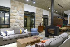 ein Wohnzimmer mit Sofa und Kamin in der Unterkunft Villa Pnai in Rosch Pina
