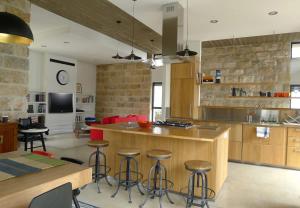eine Küche mit einer Kochinsel und Barhockern in der Unterkunft Villa Pnai in Rosch Pina + 42 Fotos