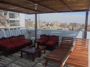 a balcony with couches and tables on a roof at Lola Hosting in Huanchaco
