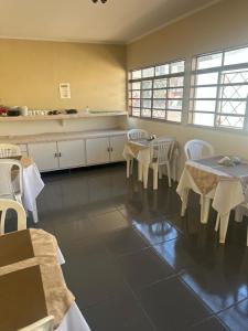 a kitchen with tables and chairs in a room at Cardoso Palace Hotel Ouro Verde in Rio Verde