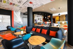 a restaurant with colorful chairs and tables and a bar at Ibis budget Dijon Centre Clemenceau in Dijon