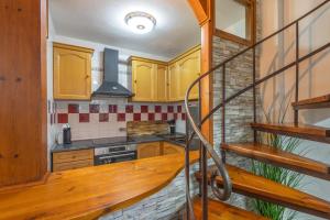 a kitchen with wooden cabinets and a spiral staircase at Dúplex acogedor en La Molina- 8 Pax in La Molina +24 photos