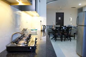 a kitchen with a stove and a dining room at Amur Stay 2 in Sohāna +27 photos