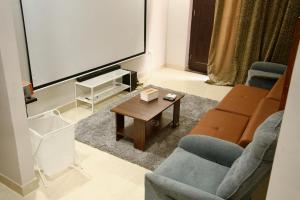 a living room with a tv and a couch and a table at Amur Stay 2 in Sohāna