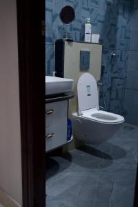 a bathroom with a white toilet and a sink at Amur Stay 2 in Sohāna