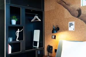 a living room with a book shelf and a television at Conscious Hotel Amsterdam City - The Tire Station in Amsterdam