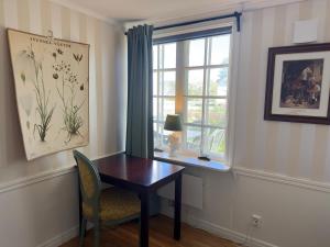 a table and a chair in a room with a window at Aspa Herrgård - Handelshuset in Askersund