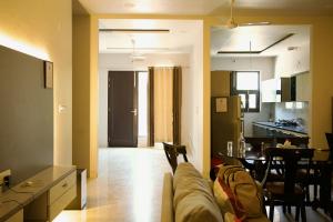 a living room and kitchen with a couch and a table at Amur Stay 2 in Sohāna