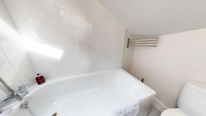 a bathroom with a white tub and a toilet at Walton Lane in Oxford +17 photos