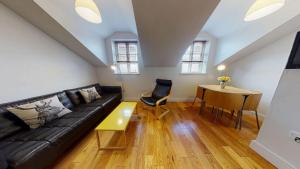 a living room with a black couch and a table at Walton Lane in Oxford