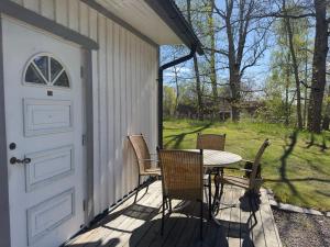 a patio with a table and chairs on a porch at Aspa Herrgård - Handelshuset in Askersund