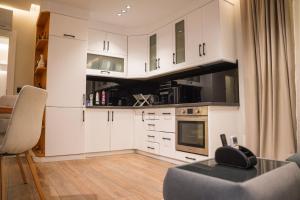 a kitchen with white cabinets and a table at Cuzi House in Librazhd