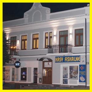 a white building with a risk testing sign in front of it at Apartamenty Ostrowiec - Pokoje Gościnne Centrum in Ostrowiec Świętokrzyski