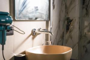 a bathroom with a gold sink and a mirror at Cuzi House in Librazhd +25 photos