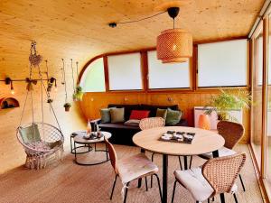 a room with a couch and a table and chairs at L'oasis des Coccinelles - 2 gîtes insolites ultra cosy in Sainte-Croix-aux-Mines