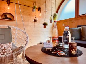 a table in a room with two bottles on it at L'oasis des Coccinelles - 2 gîtes insolites ultra cosy in Sainte-Croix-aux-Mines +80 photos