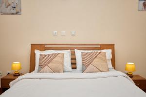 a bedroom with a white bed with two lamps at La Samurai House Assinie in Assinie +15 photos