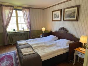 a bedroom with a large bed and a window at Aspa Herrgård - Handelshuset in Askersund