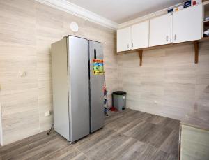 a kitchen with a stainless steel refrigerator in a room at La Samurai House Assinie in Assinie